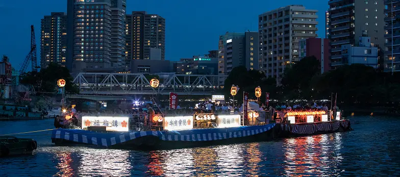 夜の天神祭船渡御で提灯の灯りに包まれた福梅講の奉仕船