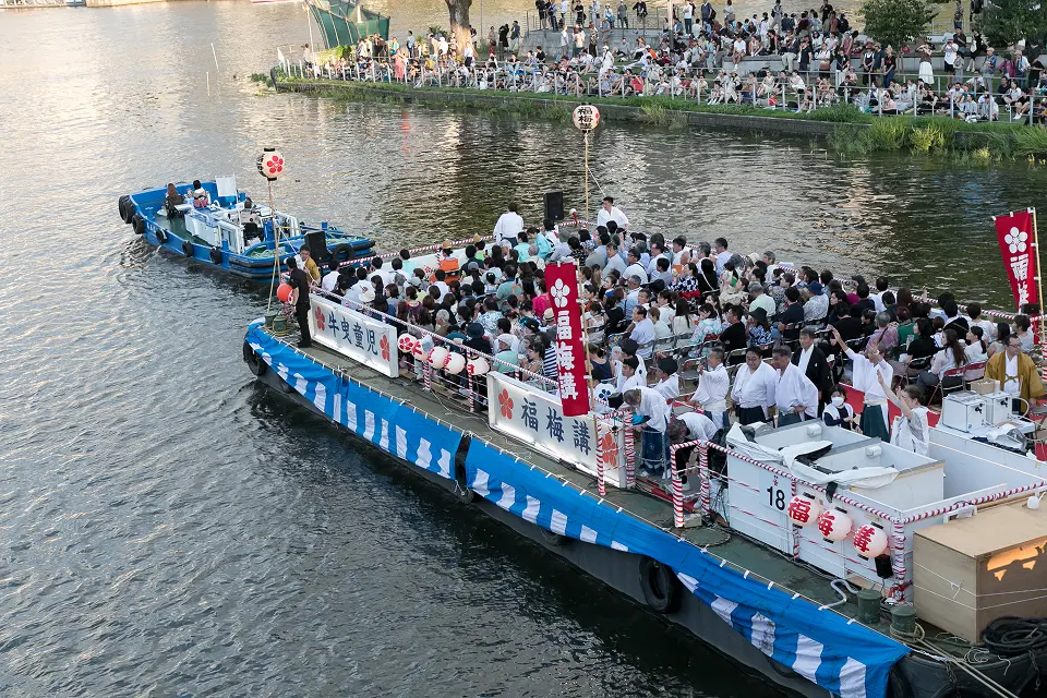 天神祭の船渡御で大川を進む福梅講の奉仕船と乗船者の様子