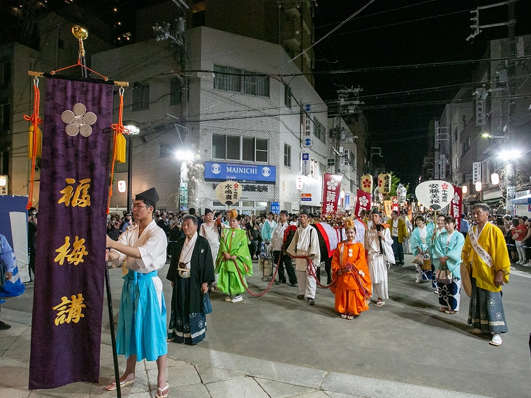 夜の天神祭で福梅講の幟を先導する行列